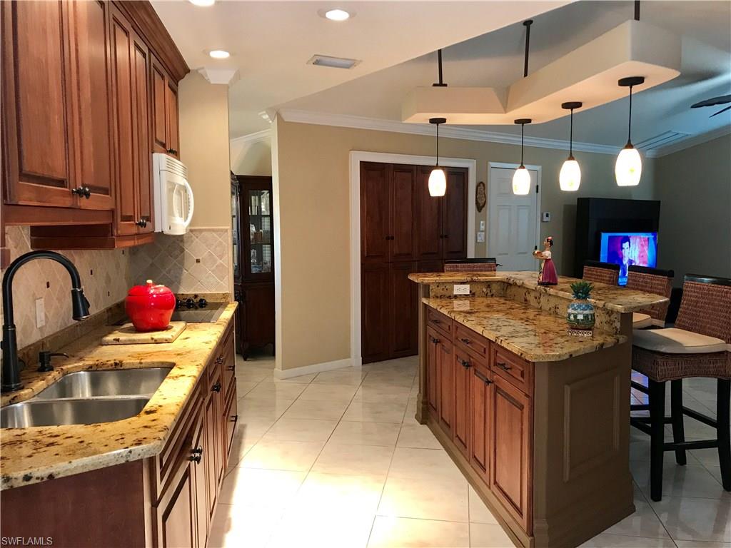 4256 31st Place Southwest Naples, FL 34116 - Photo 6 of 20 a kitchen with a stove and a refrigerator