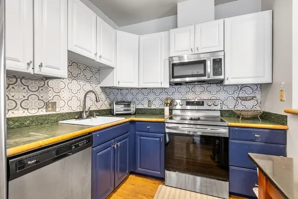a kitchen with stainless steel appliances granite countertop a sink stove and microwave