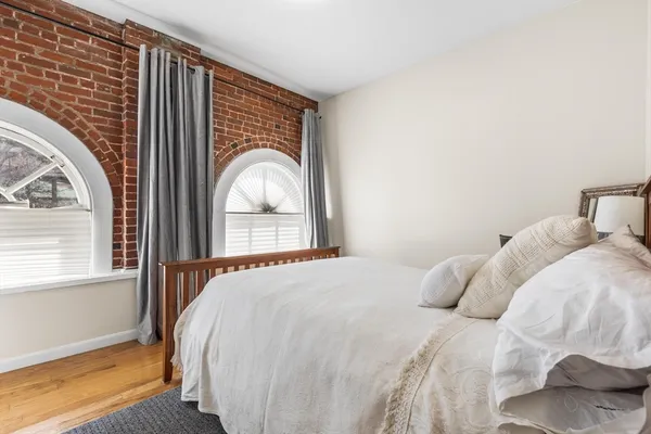 a bedroom with a bed and a large window