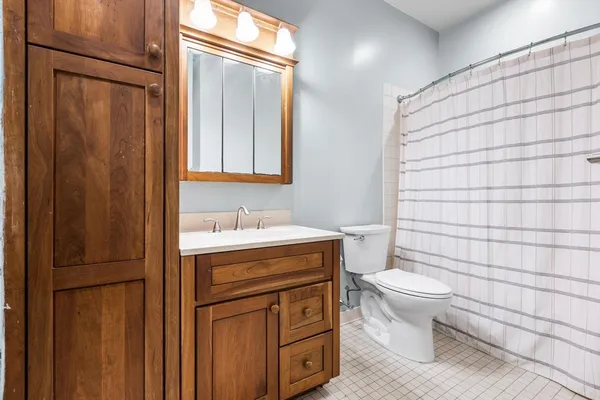 a bathroom with a granite countertop sink toilet and shower