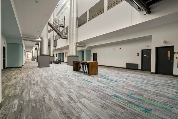 a view of a hall with wooden floor and furniture