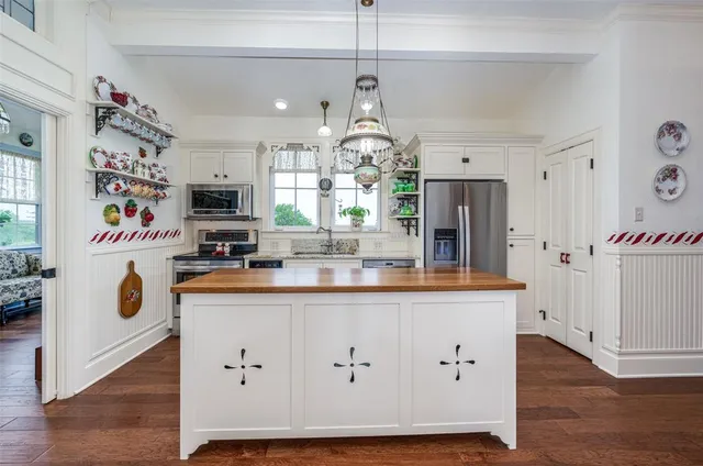 a kitchen with granite countertop a white cabinets and window