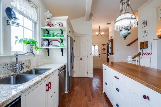 a kitchen with granite countertop a white cabinets stove and wooden floor