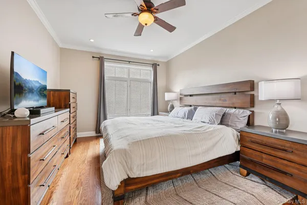 a bedroom with a bed and a flat tv screen on dresser