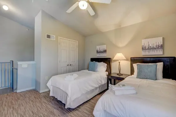 a bedroom with two beds and a night stand