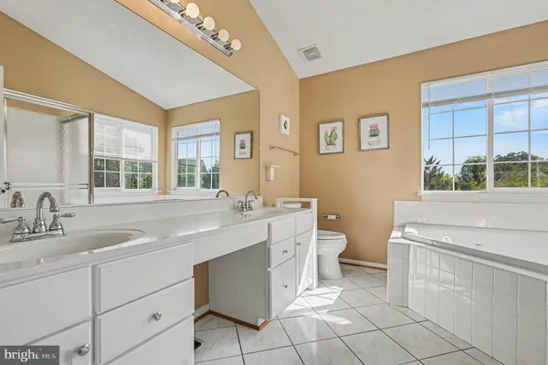 a bathroom with a granite countertop toilet sink and mirror