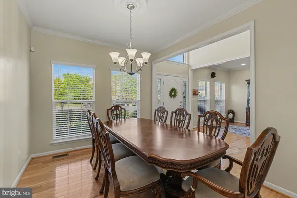 a dining room with furniture a chandelier and wooden floor