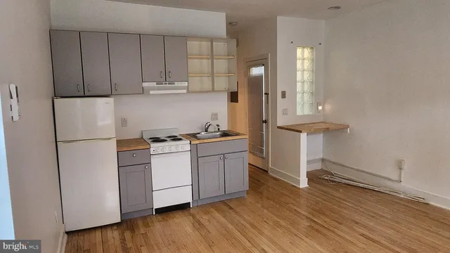 a kitchen with a refrigerator and white cabinets