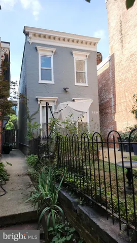 a view of a house with a cars park side of road