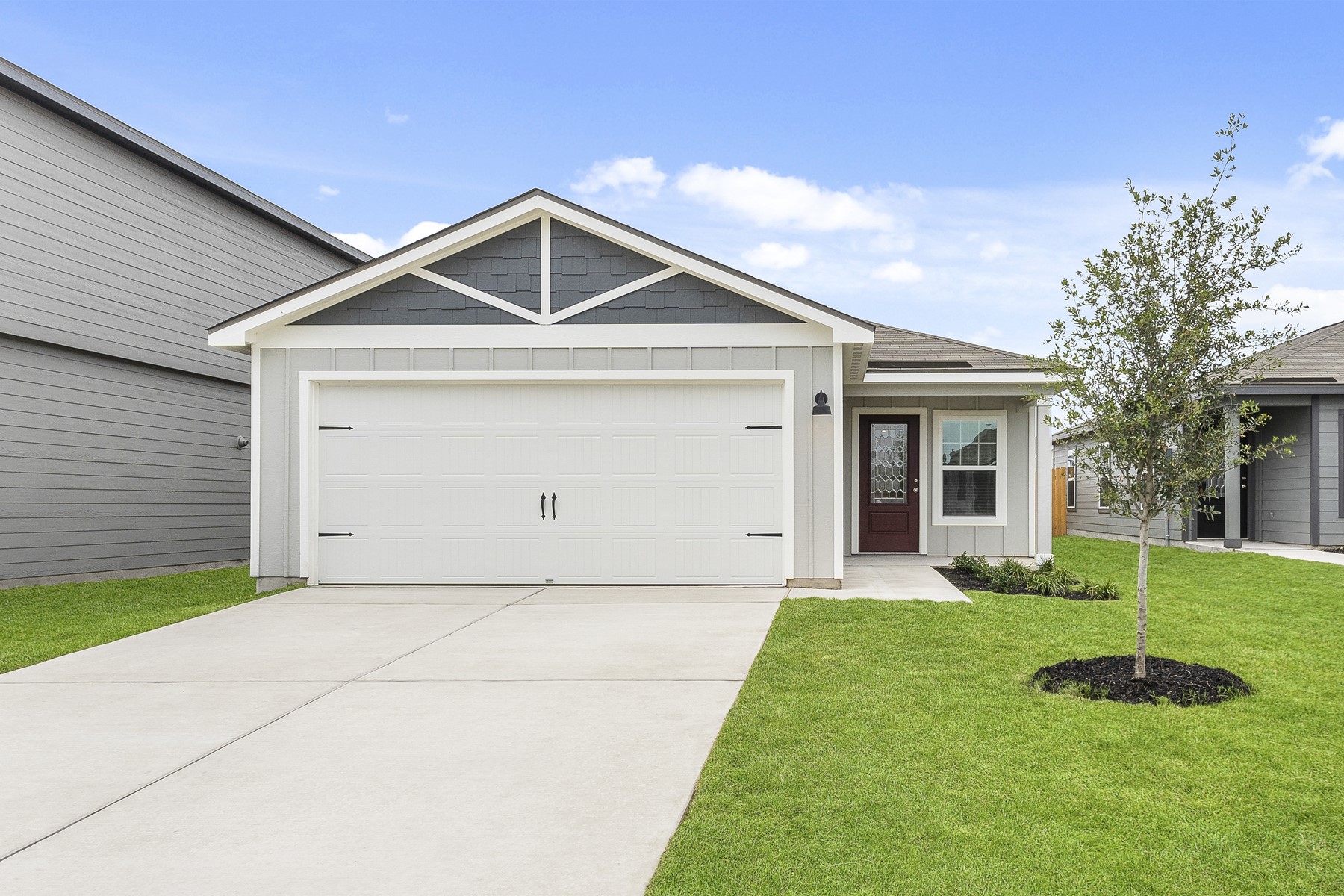 Ranch-style home with board and batten siding, a front yard, driveway, and a garage