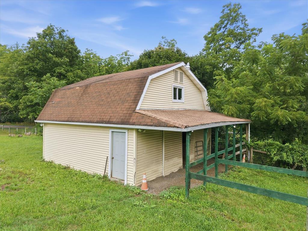 7722 Sechler Road New Tripoli, PA 18066 - Photo 46 of 58 A gambrel roof barn features a covered lean-to area and a grassy surrounding pasture.