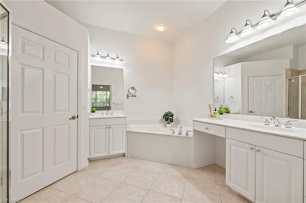 a bathroom with a sink a tub and a mirror