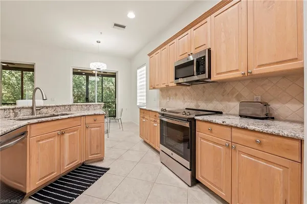 a kitchen with stainless steel appliances granite countertop a sink and a stove top oven