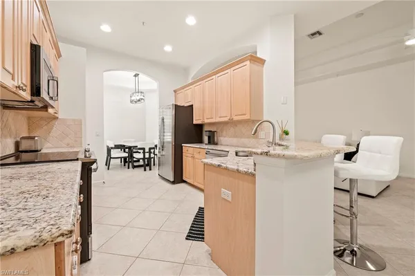 a kitchen with kitchen island granite countertop a sink appliances cabinets and furniture