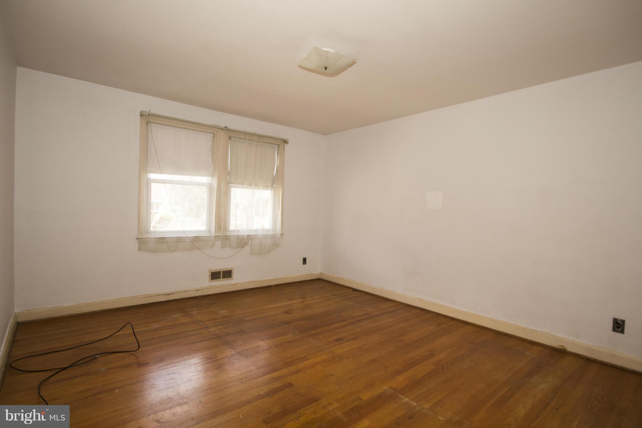 1673 Northbourne Road Baltimore, MD 21239 - Photo 11 of 21 an empty room with wooden floor and windows