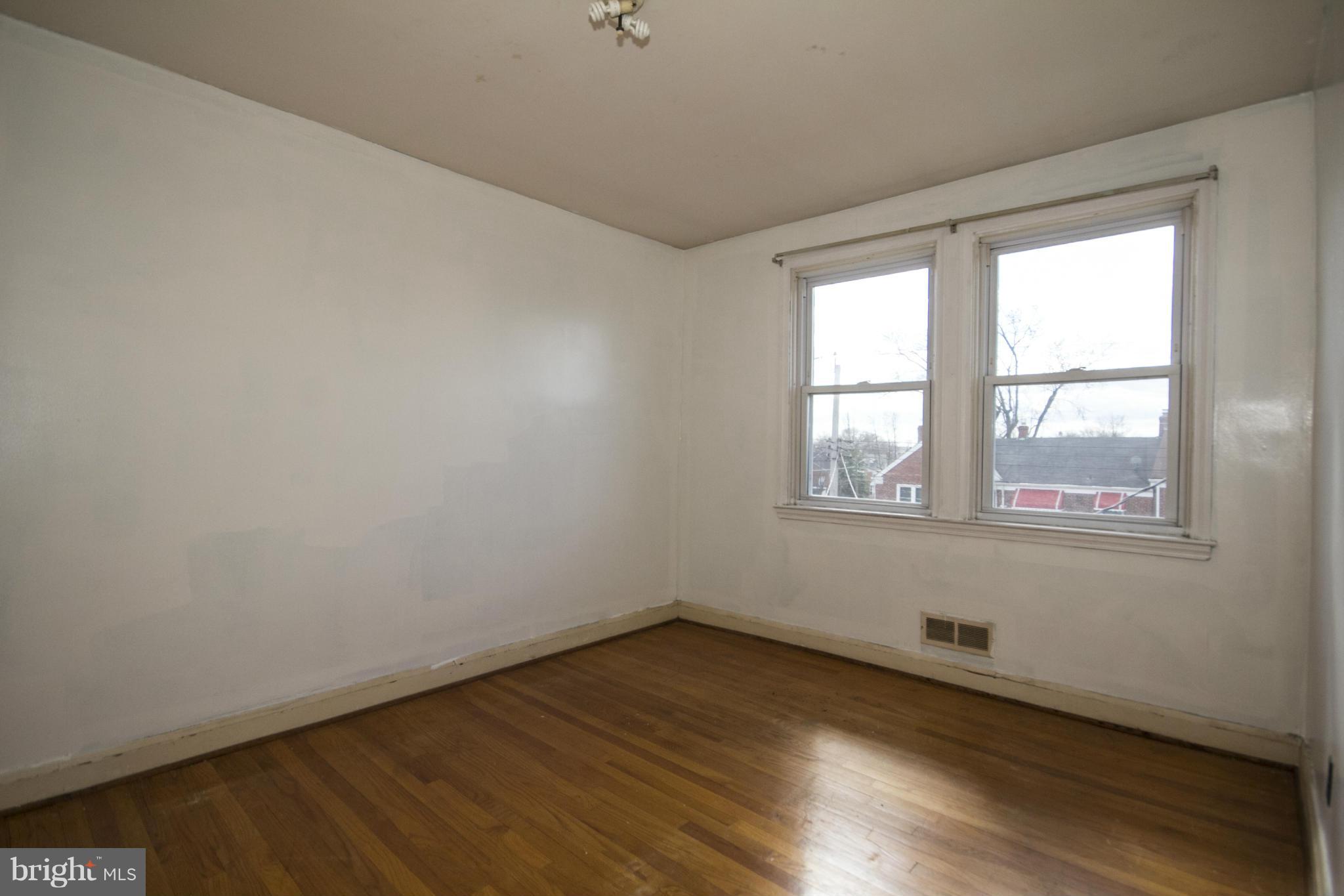 1673 Northbourne Road Baltimore, MD 21239 - Photo 13 of 21 an empty room with wooden floor and windows