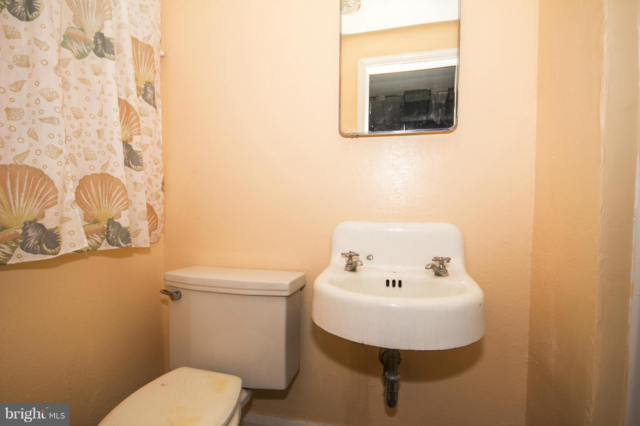 1673 Northbourne Road Baltimore, MD 21239 - Photo 19 of 21 a bathroom with a sink mirror and toilet