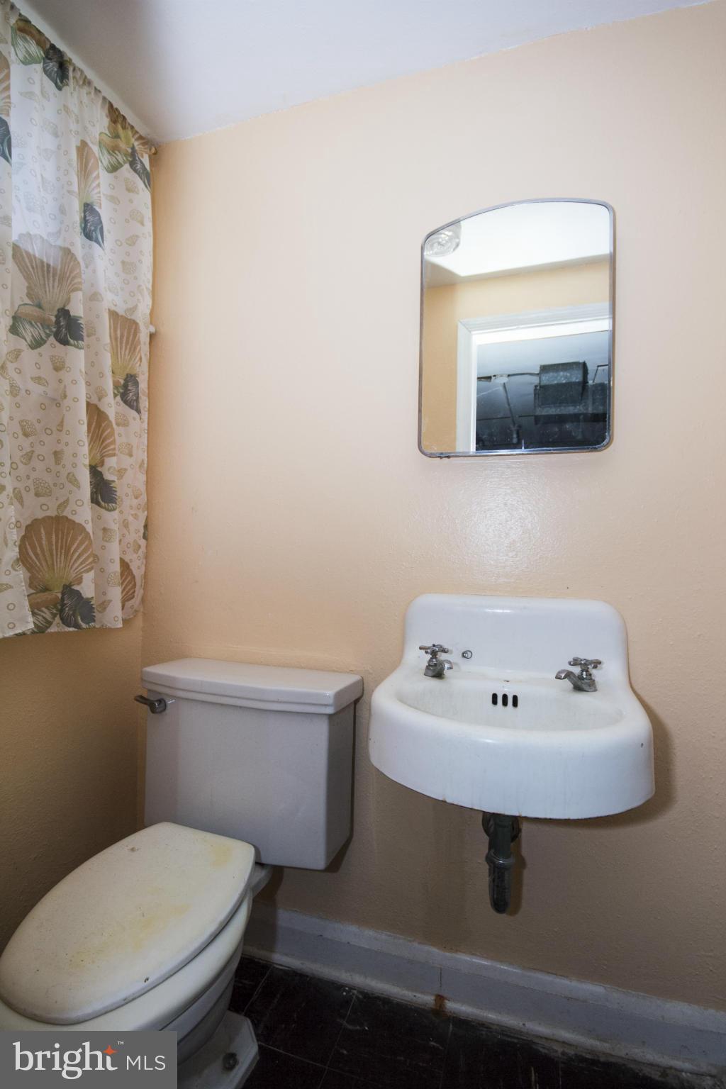 1673 Northbourne Road Baltimore, MD 21239 - Photo 20 of 21 a bathroom with a sink a toilet and mirror