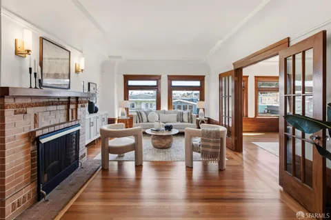 a living room with fireplace furniture and a large window
