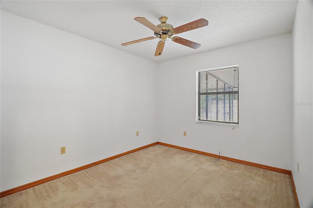 501 Cherry Tree Street Eustis, FL 32726 - Photo 22 of 35 an empty room with ceiling fan and window