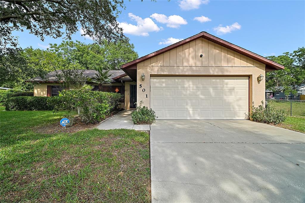 501 Cherry Tree Street Eustis, FL 32726 - Photo 3 of 35 a front view of a house with a yard and garage