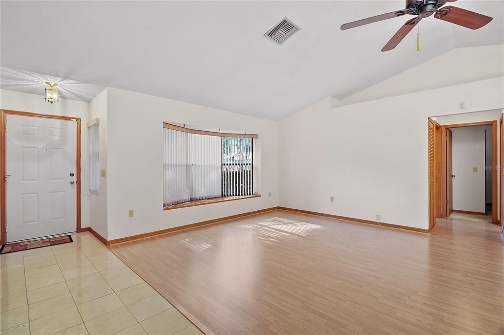 501 Cherry Tree Street Eustis, FL 32726 - Photo 5 of 35 an empty room with wooden floor cabinet and windows