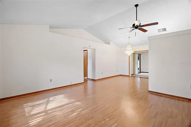 a view of a room with wooden floor and ceiling fan