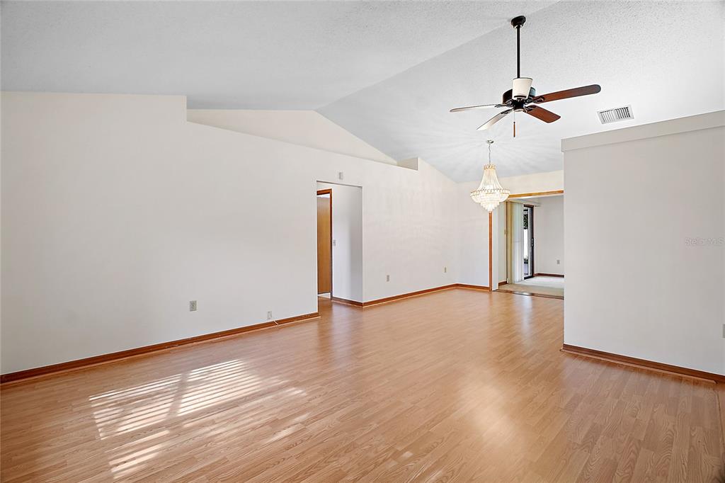501 Cherry Tree Street Eustis, FL 32726 - Photo 7 of 35 a view of a room with wooden floor and ceiling fan