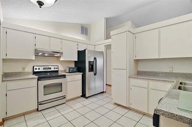 a kitchen with cabinets and steel stainless steel appliances
