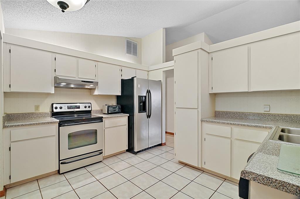 501 Cherry Tree Street Eustis, FL 32726 - Photo 10 of 35 a kitchen with cabinets and steel stainless steel appliances