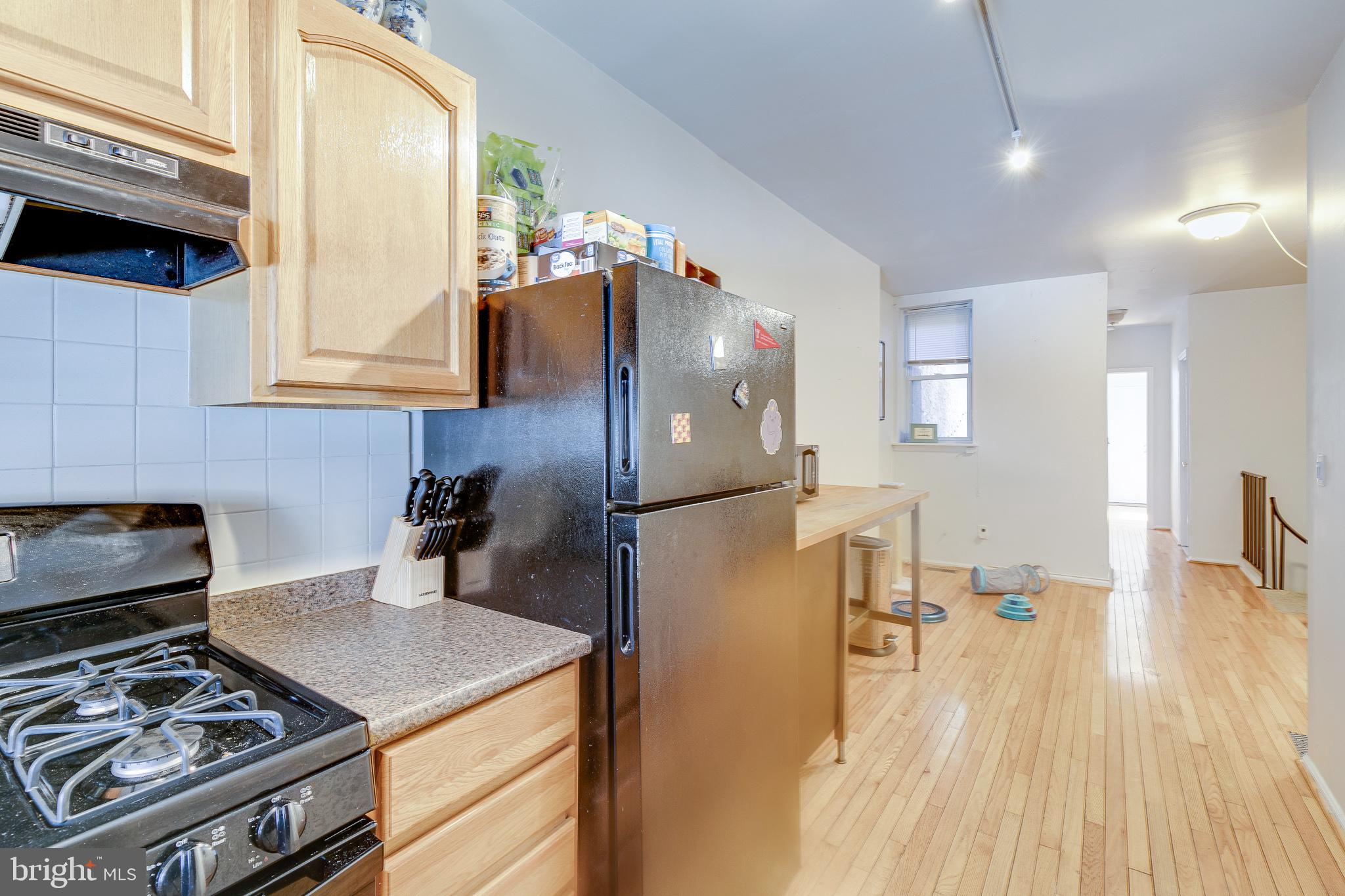 1004 Christian Street Philadelphia, PA 19147 - Photo 5 of 34 a kitchen with a stove a refrigerator and a wooden cabinets