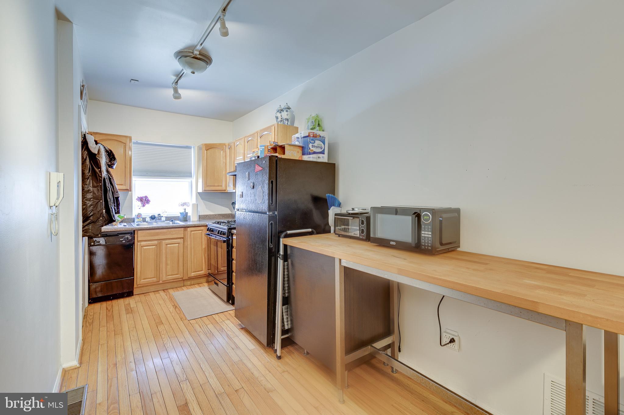 1004 Christian Street Philadelphia, PA 19147 - Photo 8 of 34 a kitchen with refrigerator cabinets and wooden floor