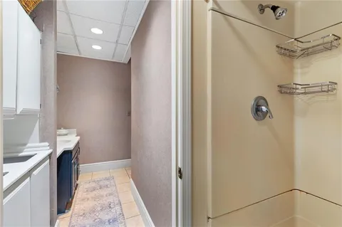 a bathroom with a granite countertop sink a mirror and shower
