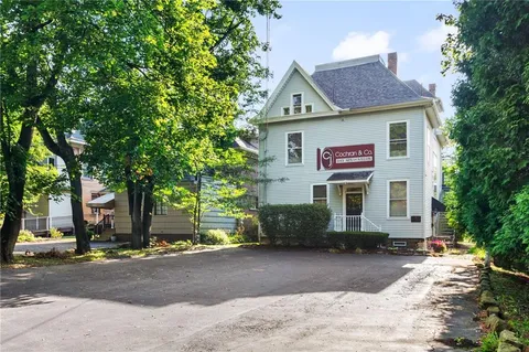 a view of a house with a yard and potted plants