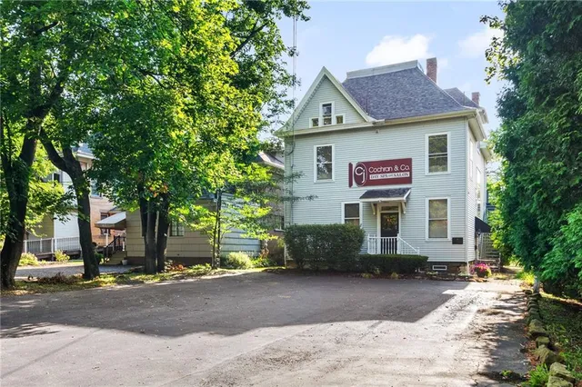 a view of a house with a yard and potted plants