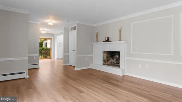 a view of a livingroom with wooden floor and a fireplace
