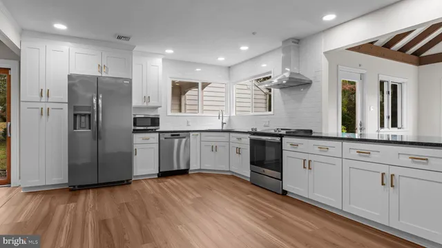 a kitchen with stainless steel appliances a refrigerator sink and cabinets