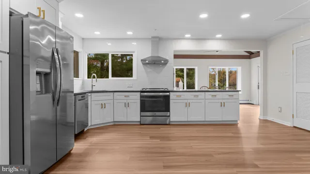 a kitchen with stainless steel appliances granite countertop a refrigerator and a sink