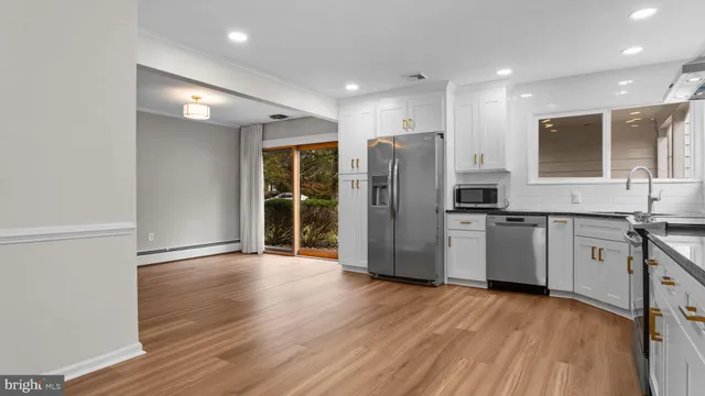 a view of kitchen with stainless steel appliances refrigerator stove microwave and cabinets