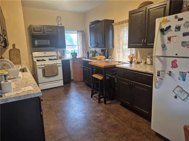 a kitchen with stainless steel appliances granite countertop sink stove top oven and cabinets