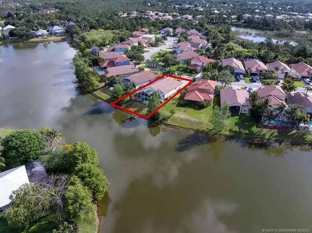an aerial view of residential houses with outdoor space and lake view