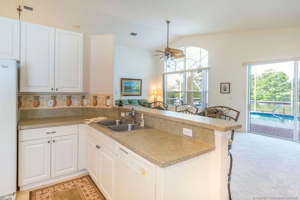 2096 Northwest Marsh Rabbit Lane Stuart, FL 34994 - Photo 35 of 58 a kitchen with a sink a counter top space and living room view