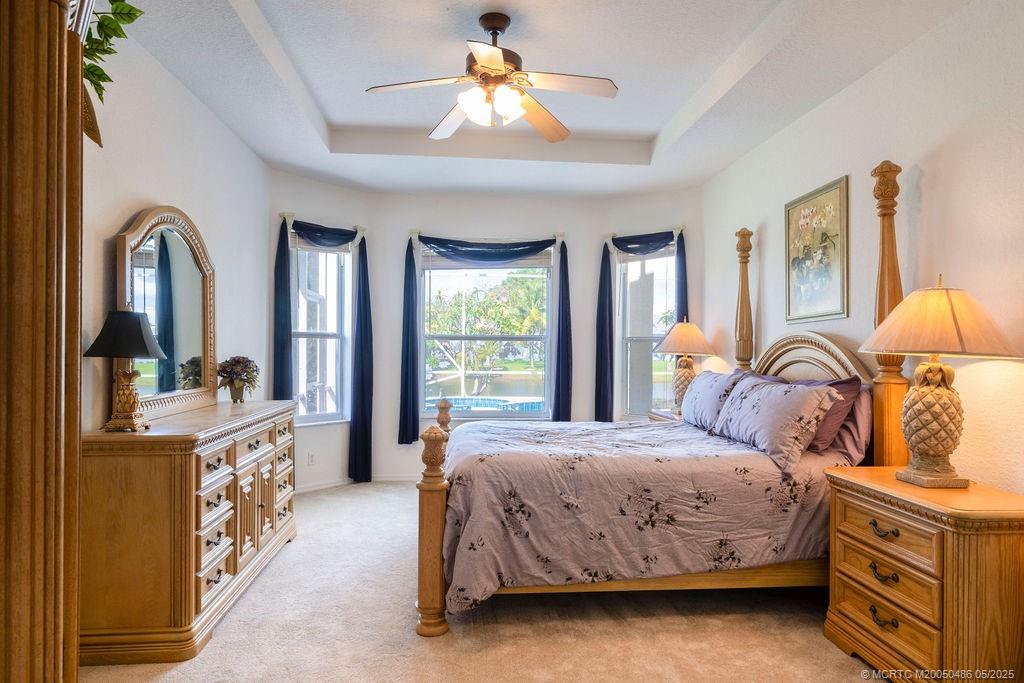 2096 Northwest Marsh Rabbit Lane Stuart, FL 34994 - Photo 45 of 58 a bedroom with a bed and a chandelier