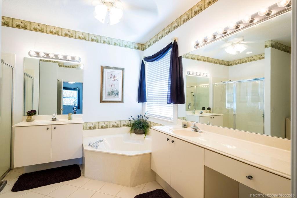 2096 Northwest Marsh Rabbit Lane Stuart, FL 34994 - Photo 46 of 58 a bathroom with a sink a large mirror and a bathtub