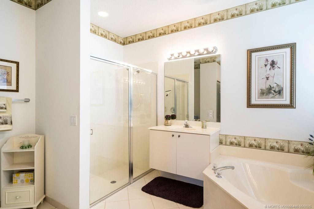 2096 Northwest Marsh Rabbit Lane Stuart, FL 34994 - Photo 48 of 58 a bathroom with a bathtub a sink and a mirror
