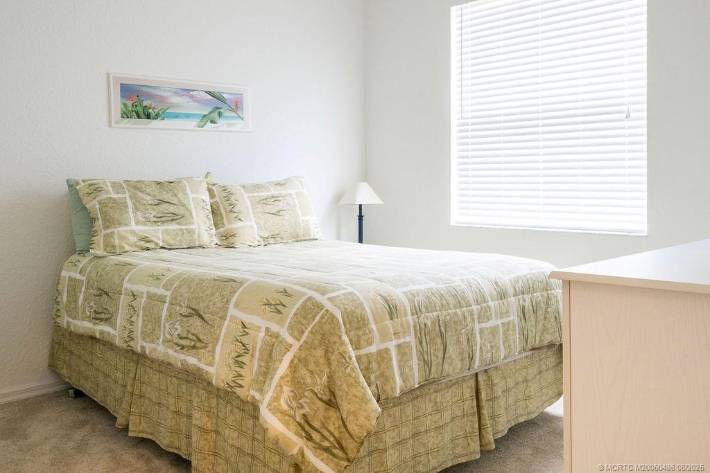2096 Northwest Marsh Rabbit Lane Stuart, FL 34994 - Photo 50 of 58 a spacious bedroom with a bed and a window