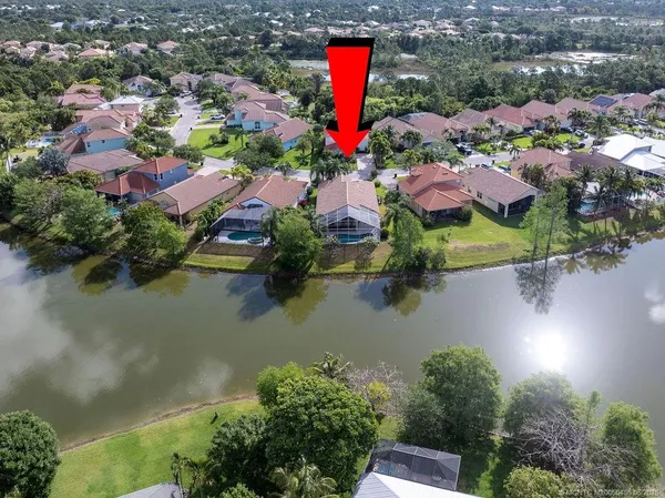 an aerial view of residential houses with outdoor space and lake view