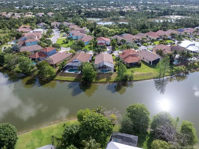 an aerial view of residential houses with outdoor space and lake view