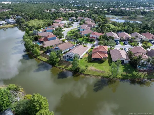 an aerial view of residential houses with outdoor space and lake view