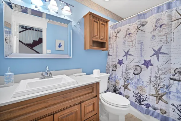 a bathroom with a sink toilet and mirror